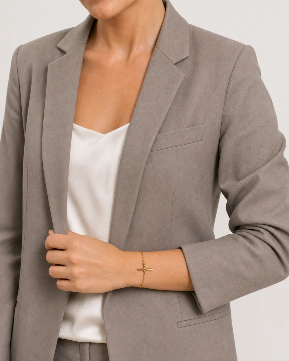 Human-scale styling detail of the Lucille bracelet with taupe tailoring
