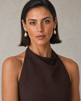 Bob-haired model wearing Luma gold teardrop earrings with a confident direct gaze