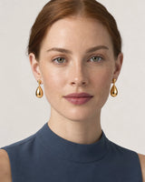 Front studio portrait wearing Luma gold teardrop earrings