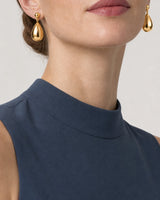 Eye-free mouth and chin crop wearing Luma gold teardrop earrings