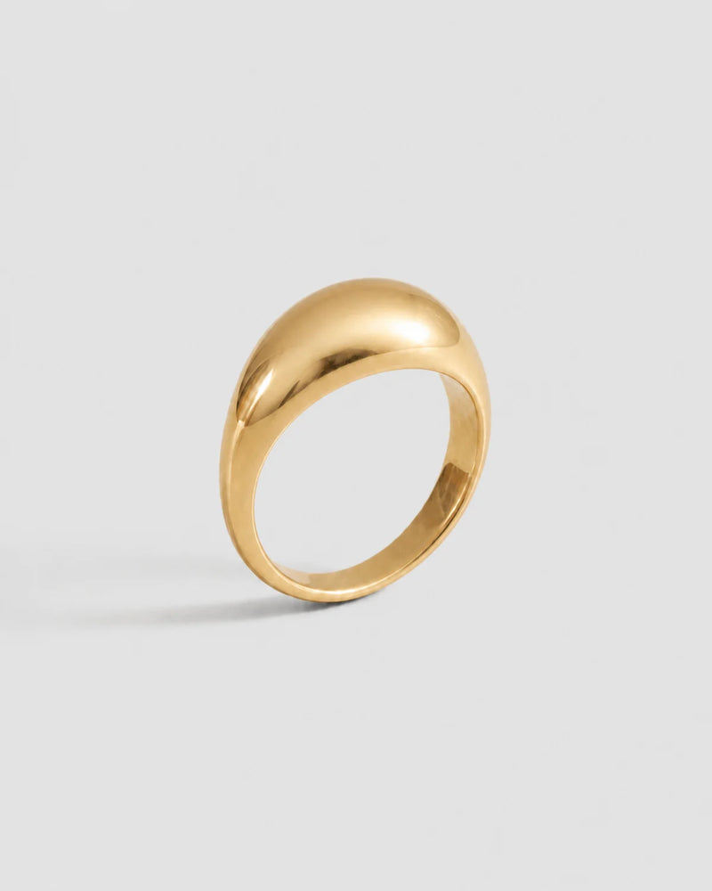 Lune polished gold dome ring on a seamless pale dove-grey studio background