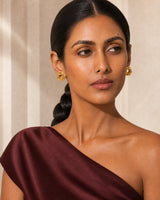 Three-quarter model portrait wearing Lyra knot earrings with a reflective gaze