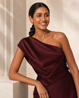 Smiling model beside limestone wearing Lyra gold circle knot earrings