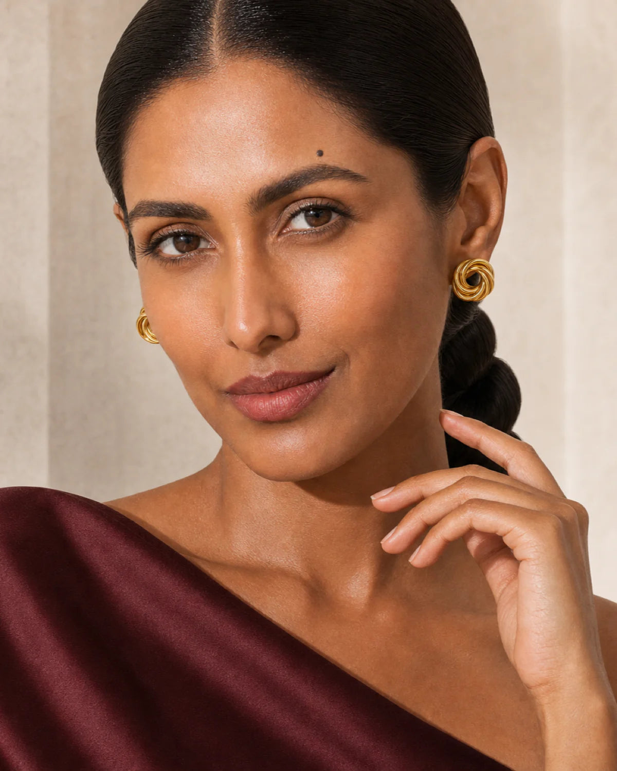 Model wearing Lyra circle knot studs beside her jaw at true scale