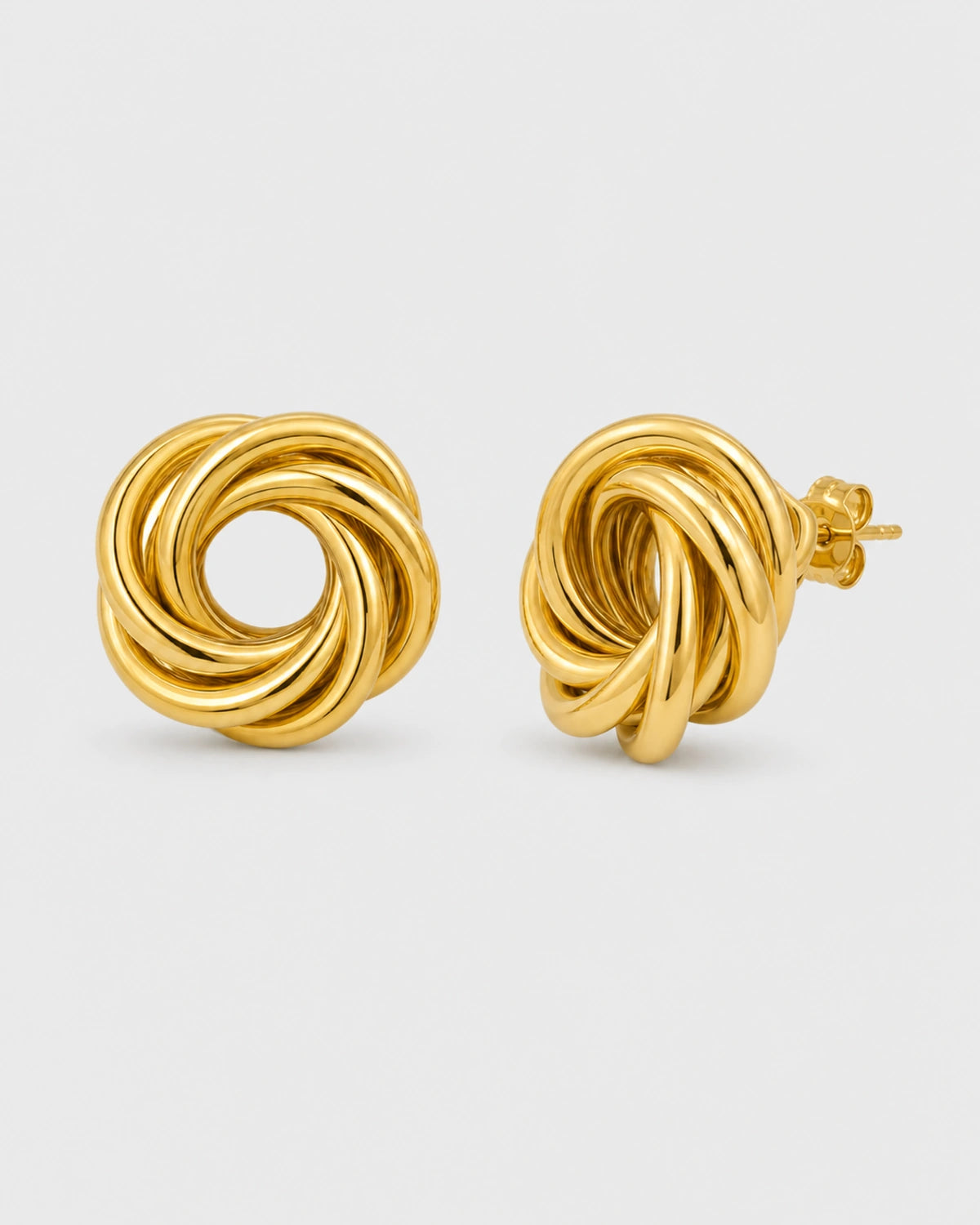 Lyra gold circle knot stud earrings on warm soft ivory