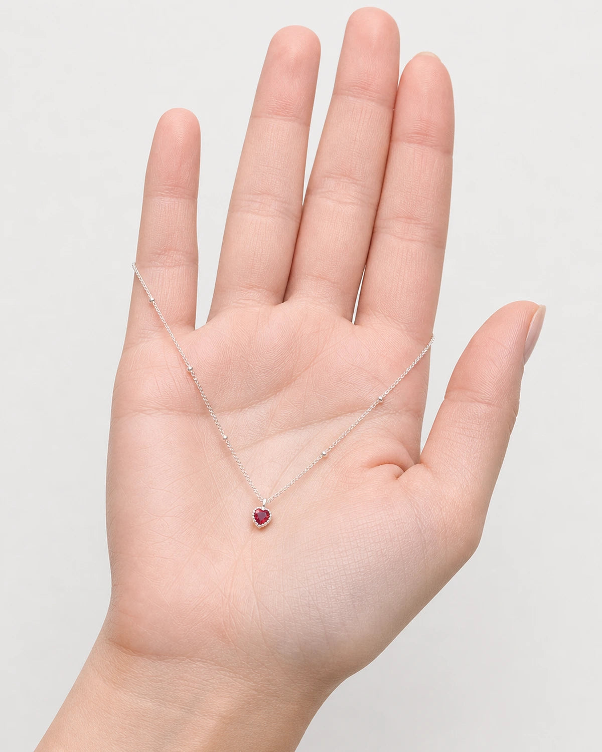 Hand-held scale view of the Maëlle silver station necklace