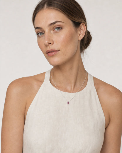 Model in an ivory Amalfi linen halter wearing the Maëlle crimson heart necklace