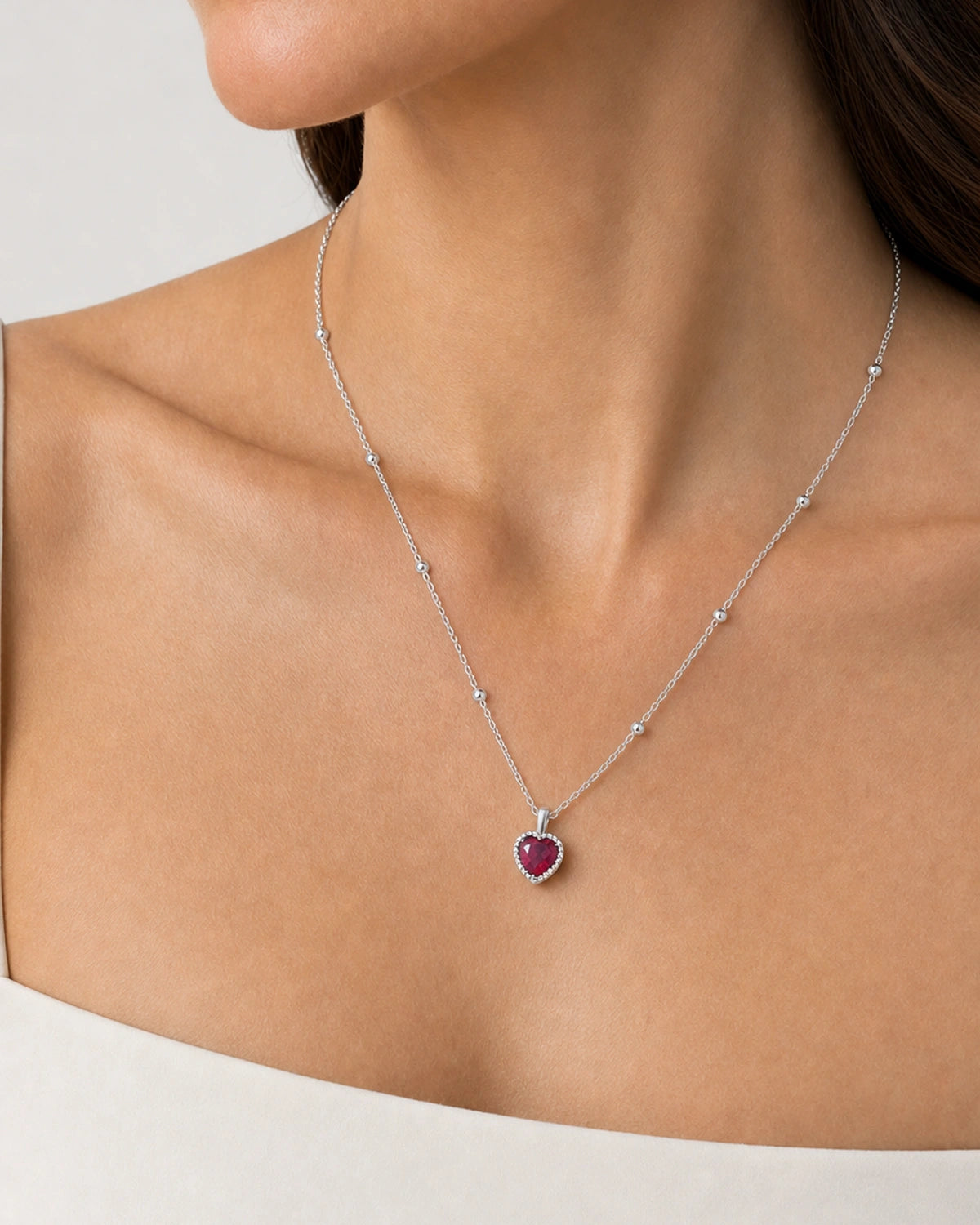 Eye-free right profile of Elise wearing the silver Maëlle crimson heart pendant