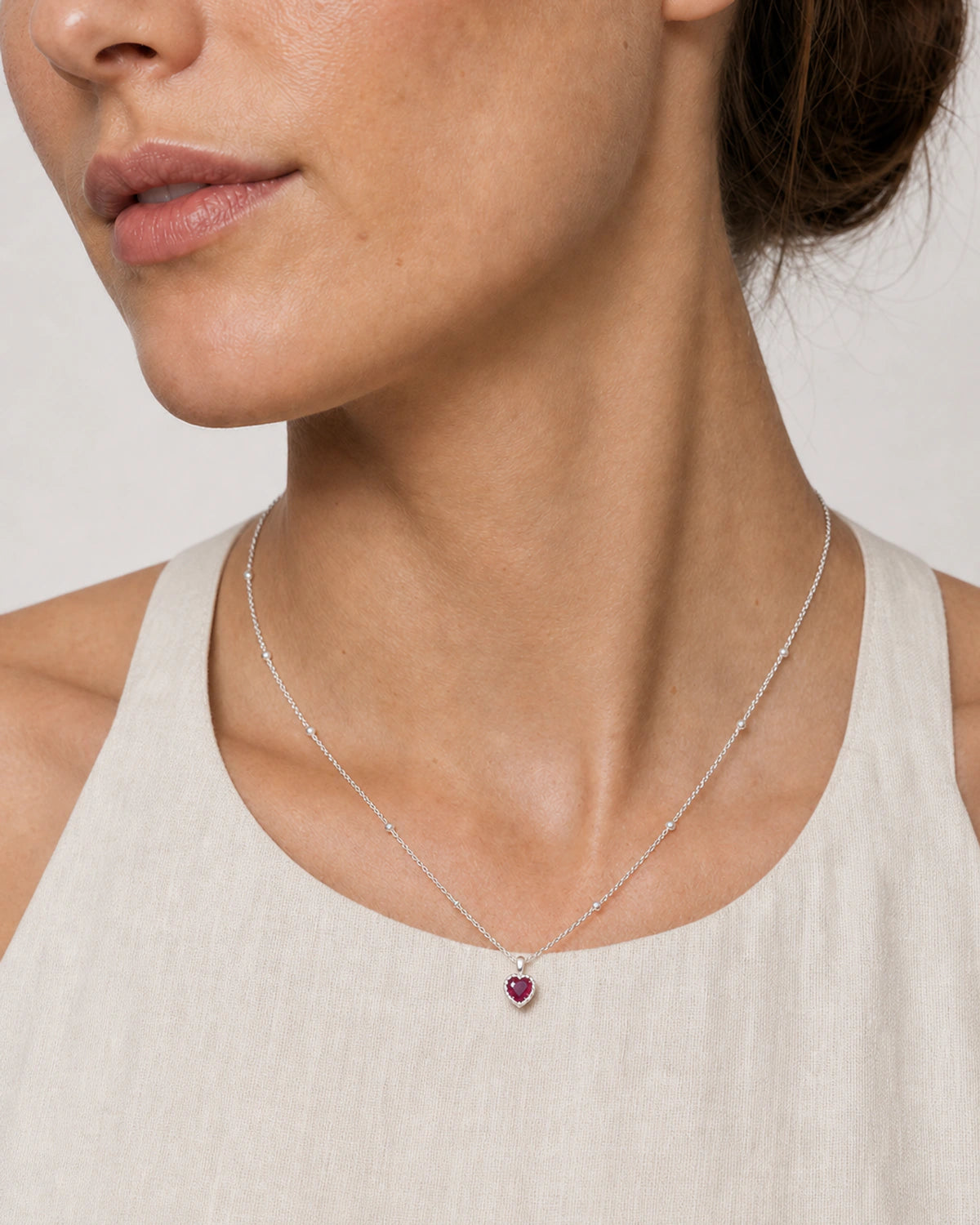 Close wearing view of the Maëlle silver station chain and crimson heart