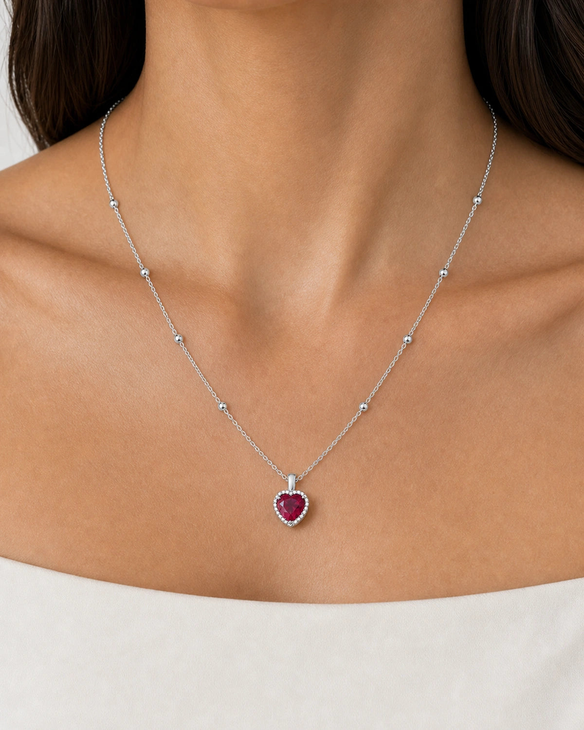 Complete worn macro of the Maëlle crimson heart station necklace at natural scale
