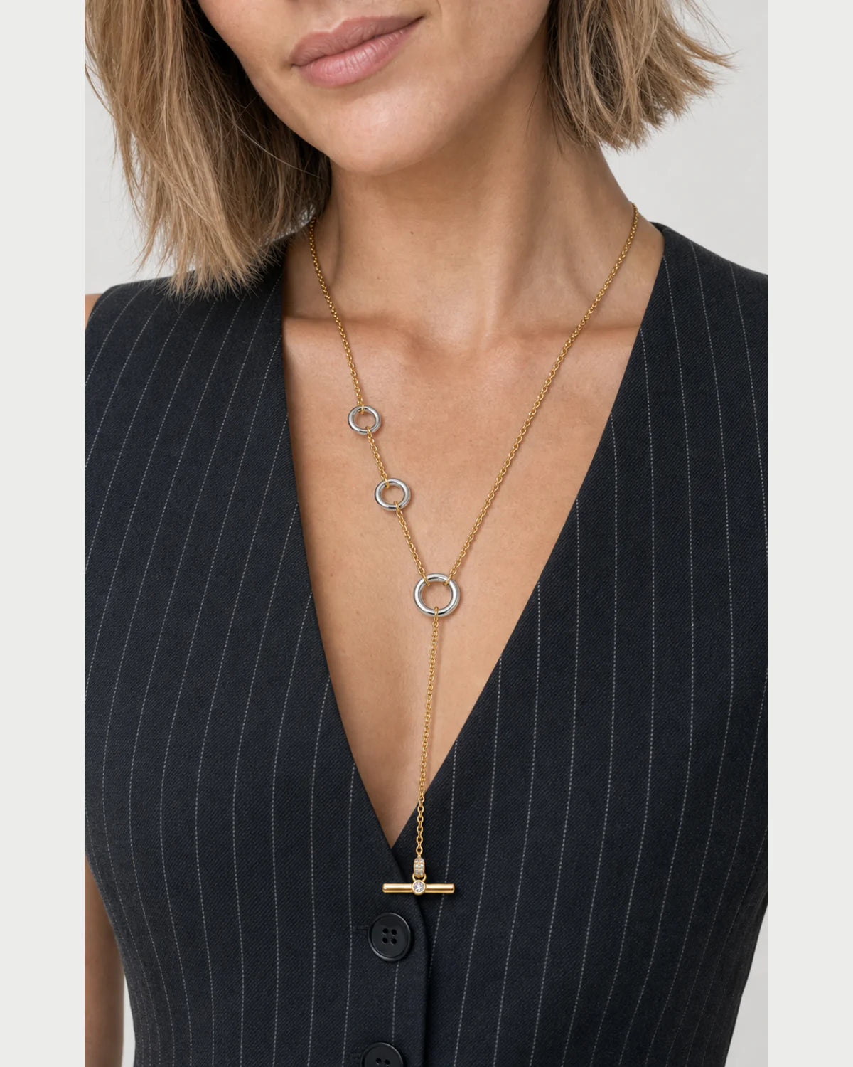 Close-up of the Marais three-ring lariat worn with pinstripe tailoring