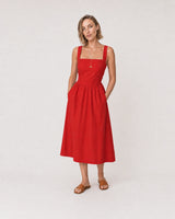 Wide studio portrait in a red poplin sundress featuring the Marais lariat
