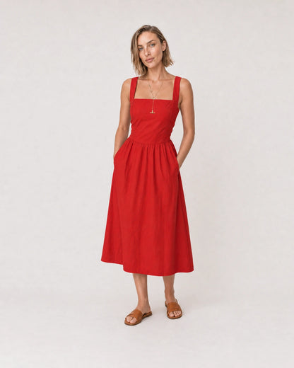 Wide studio portrait in a red poplin sundress featuring the Marais lariat