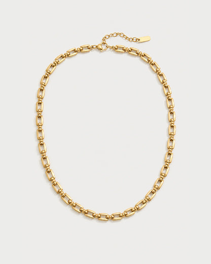 Marcelle gold sculpted link necklace on a pale dove-grey background
