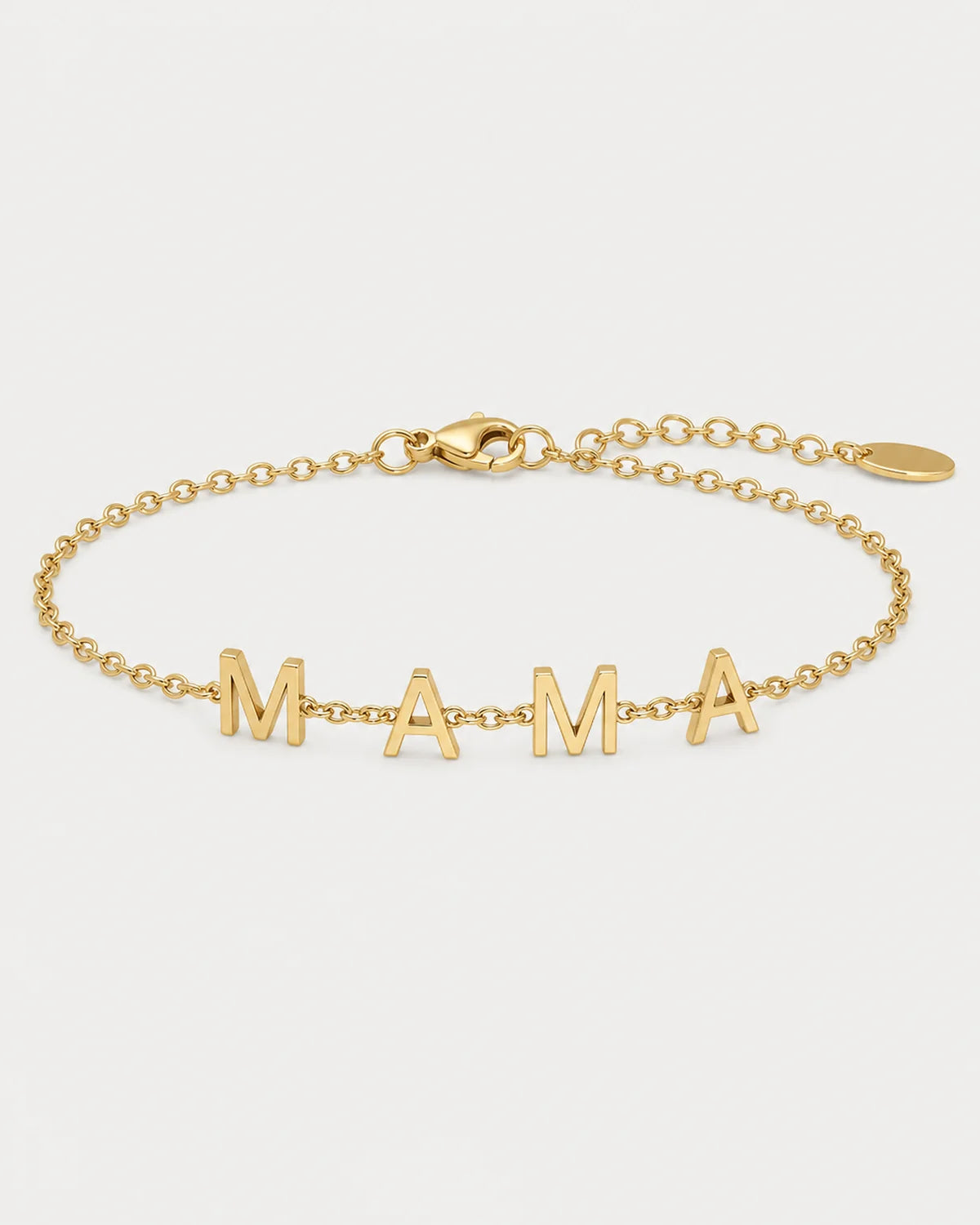 Maren gold Mama letter bracelet on a seamless pale dove-grey studio background