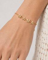Extreme wrist macro of the four polished M A M A letter charms