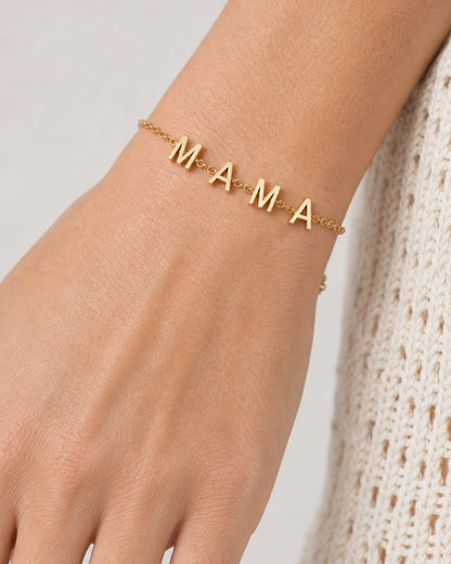 Extreme wrist macro of the four polished M A M A letter charms