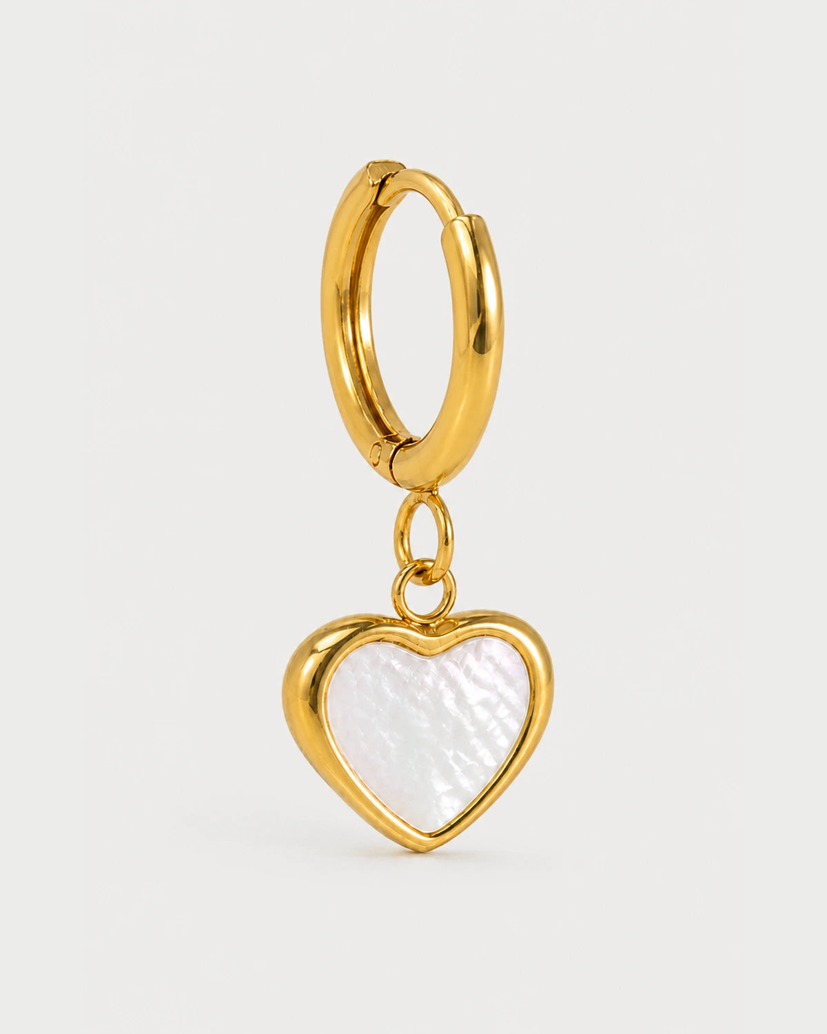 Macro detail of the Maris gold huggie connector jump ring and iridescent heart