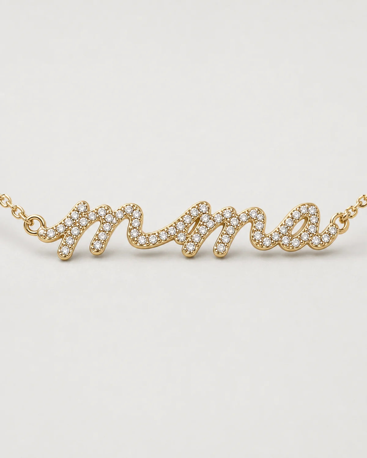 Macro of the Mila lowercase mama nameplate and clear pave stones