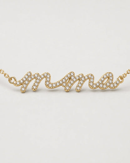 Macro of the Mila lowercase mama nameplate and clear pave stones