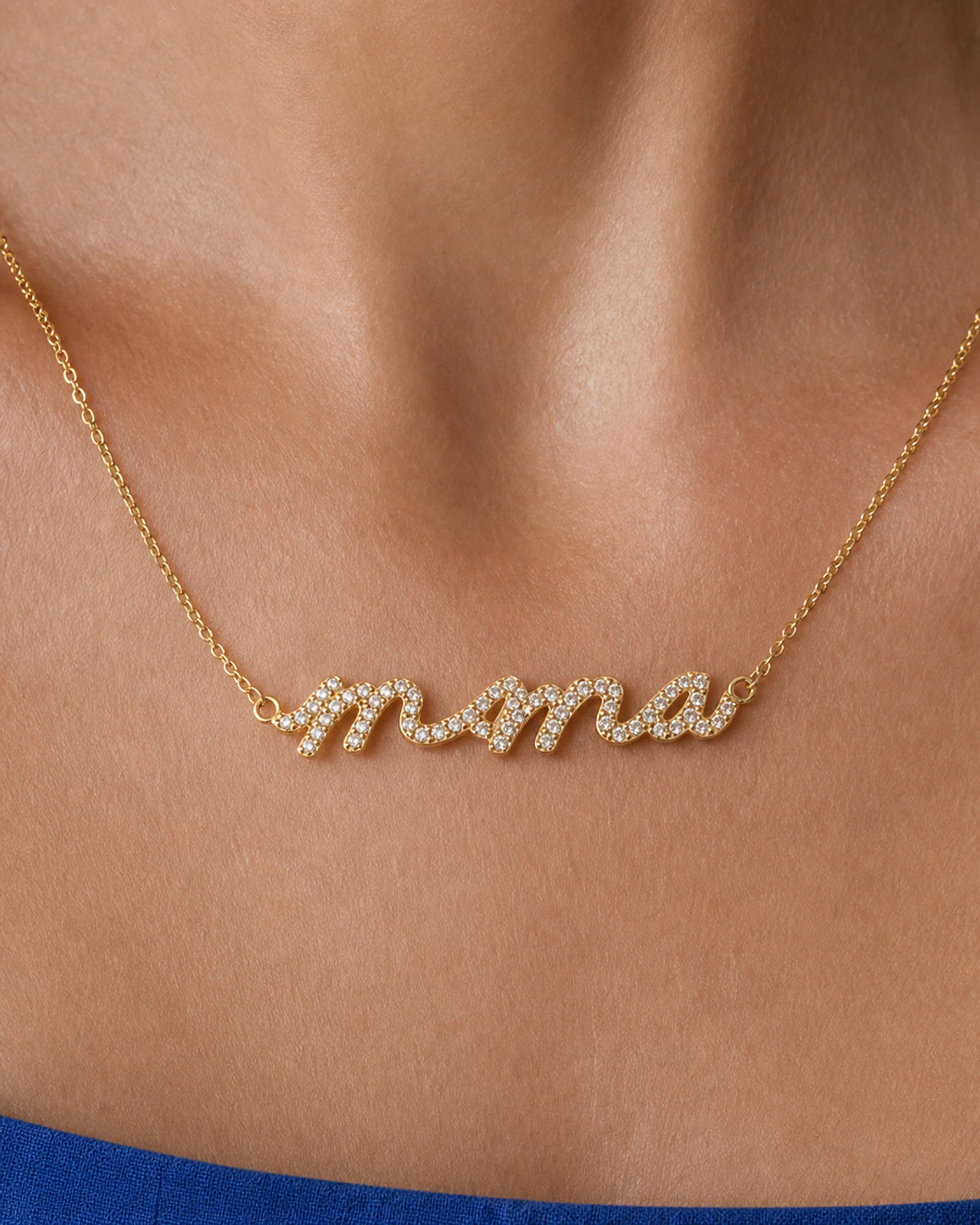Extreme on-body macro of the Mila cursive Mama nameplate and clear pave stones