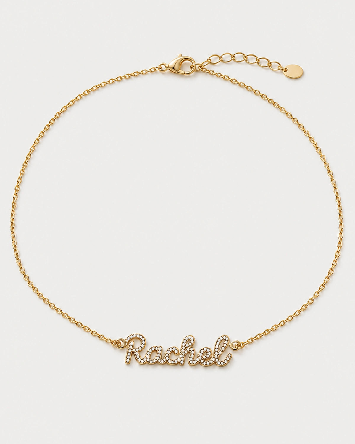Alternate complete view of the gold Mira Rachel necklace on pale neutral grey