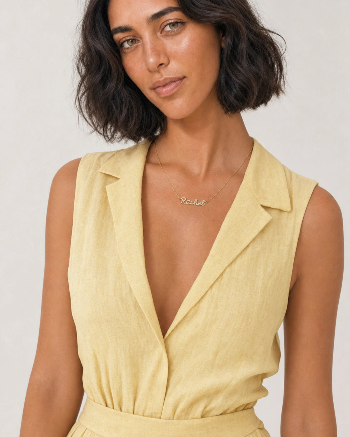 Model in a butter-yellow linen summer dress wearing the Mira Rachel necklace