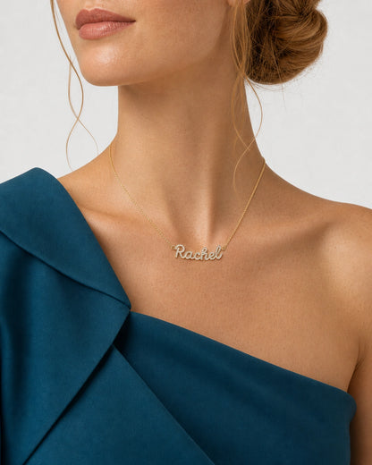Left three-quarter chin-down portrait wearing the gold Mira pavé Rachel necklace