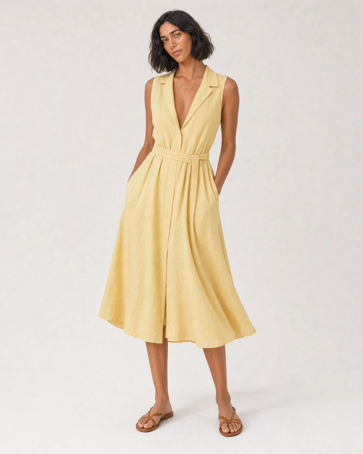 Wide studio portrait in a yellow linen midi dress featuring the Mira necklace