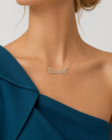 Right collarbone detail of the gold Mira Rachel nameplate at realistic scale