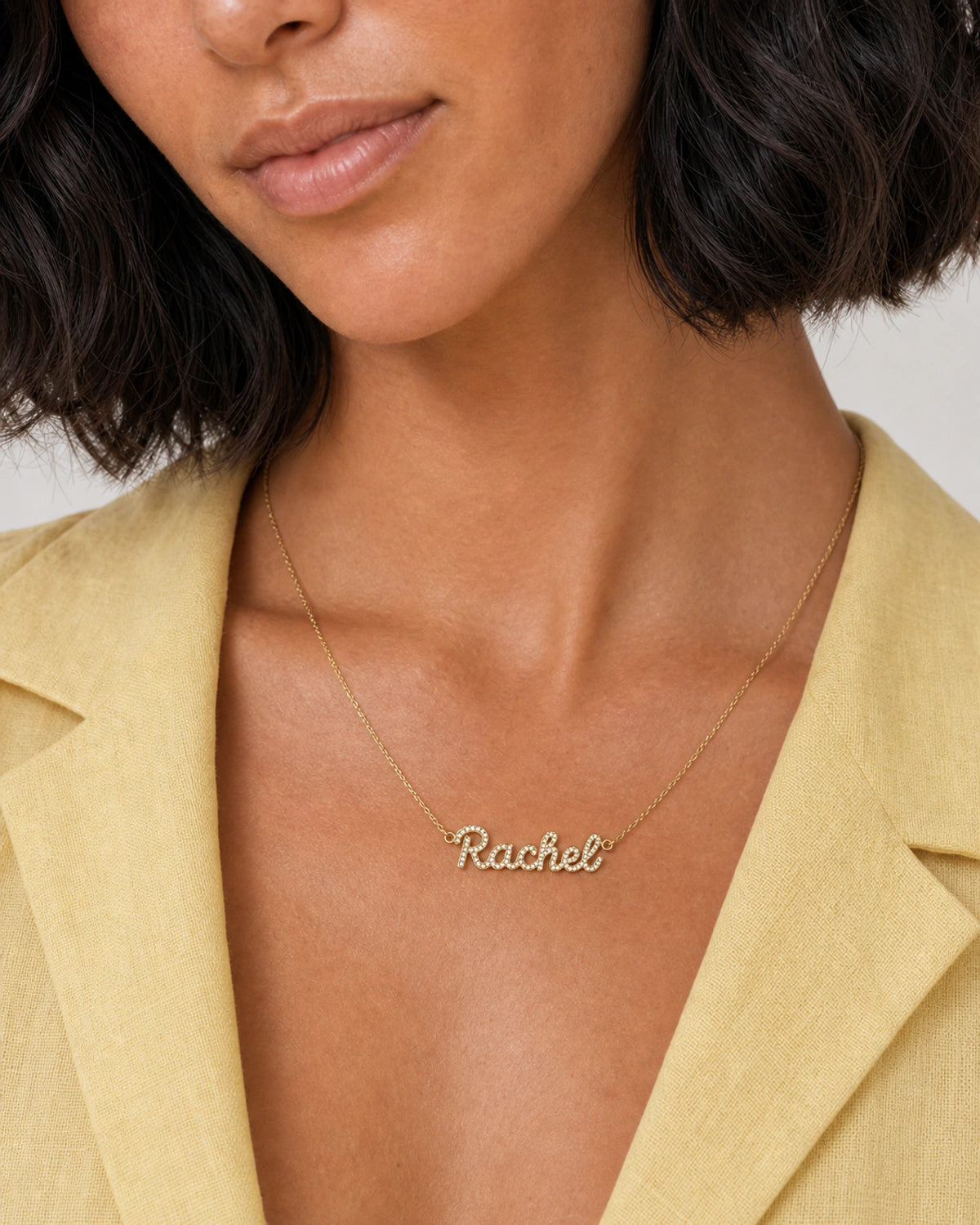 Close neckline view of the Mira cursive Rachel pave nameplate