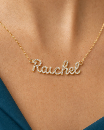 Complete worn macro of the gold Mira Rachel nameplate, integrated loops and fine chain