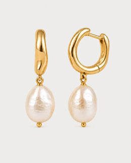 Mirelle gold pearl drop earrings on pale dove-grey
