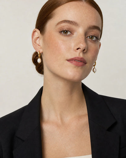 British model in black tailoring wearing Mirelle pearl earrings