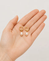 Hand-held scale view of the Mirelle pearl earring pair