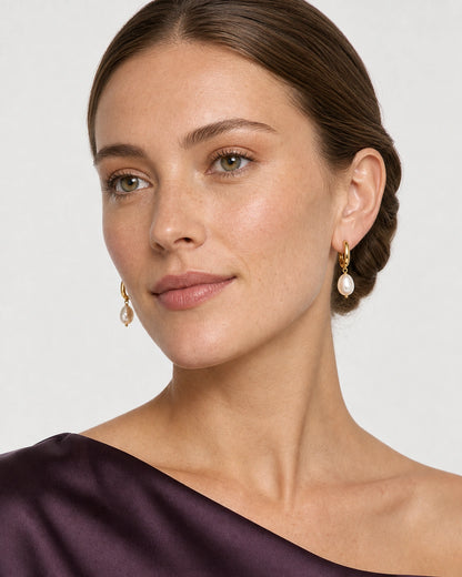 Face-inclusive portrait wearing Mirelle pearl drop earrings with aubergine silk