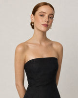 Model in a black strapless linen summer dress wearing Mirelle pearl drop earrings