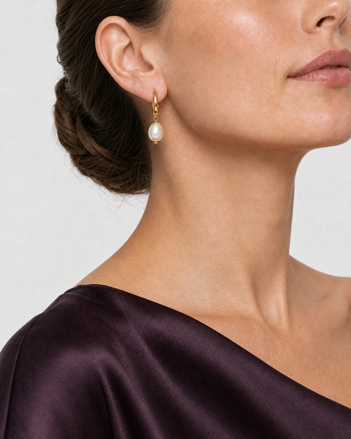 Alternate lower-face wearing view of the Mirelle gold huggie and pearl