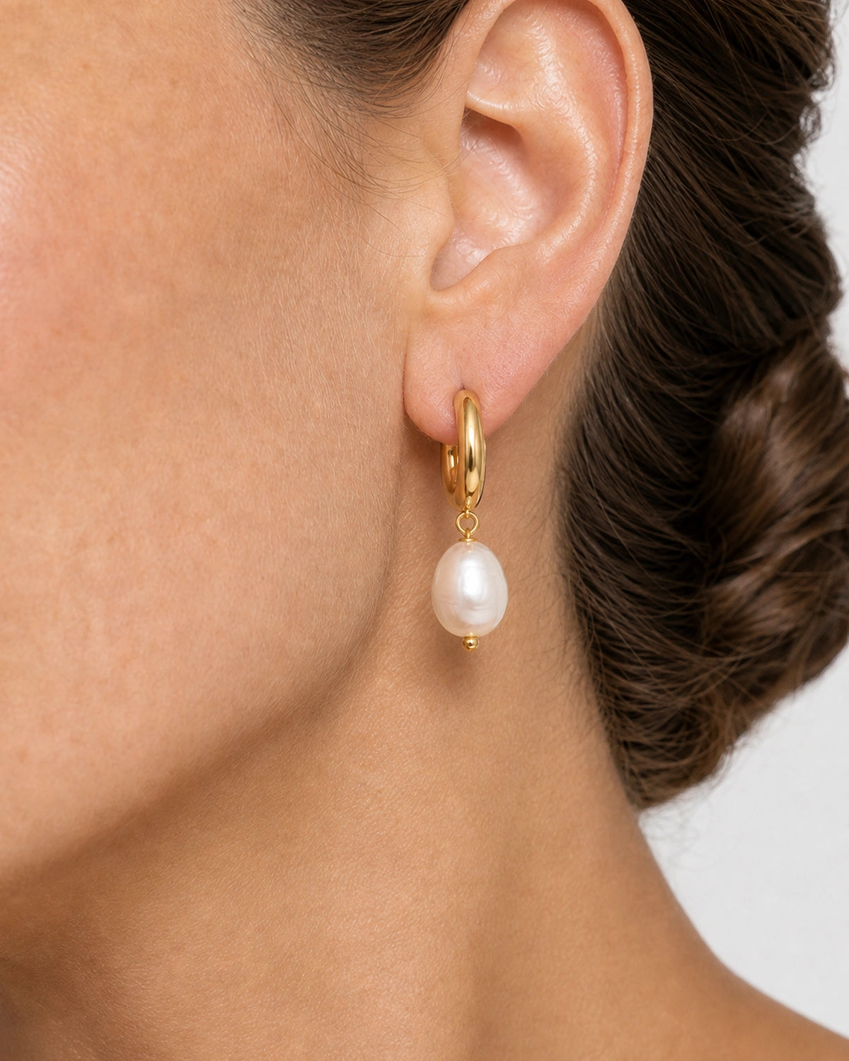 Complete worn macro of the Mirelle sculpted huggie and organic pearl