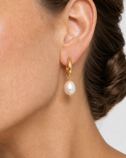 Complete worn macro of the Mirelle sculpted huggie and organic pearl