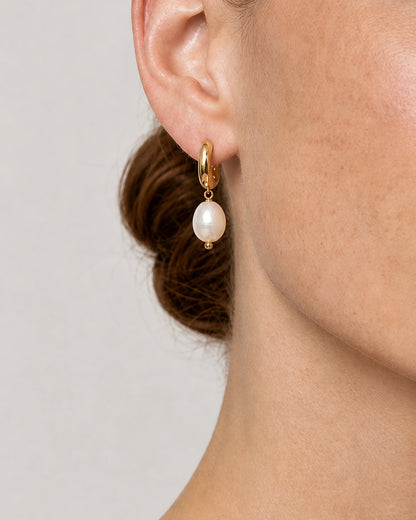 Extreme on-ear macro of the Mirelle gold huggie, connector and pearl