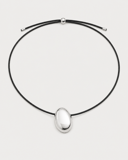 Naiya silver pebble cord necklace on a seamless pale dove-grey studio background