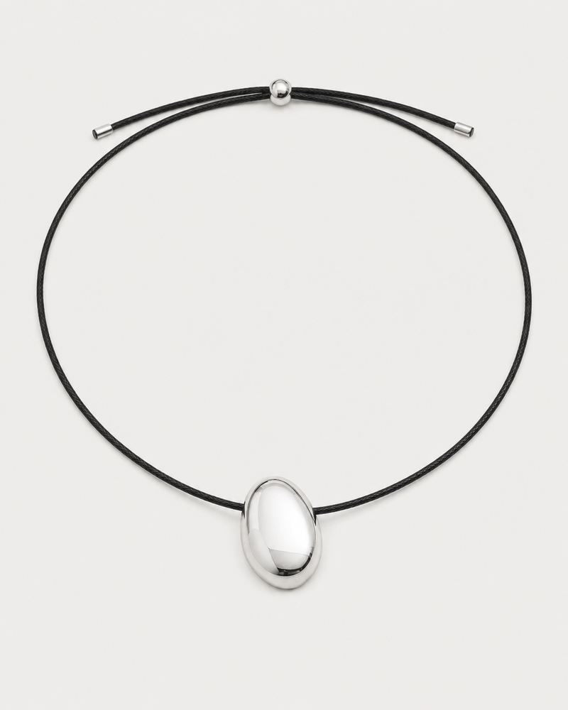 Naiya silver pebble cord necklace on a seamless pale dove-grey studio background