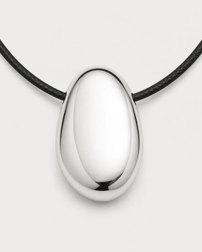 Macro front detail of the Naiya mirror-silver pebble and side-threaded black cord