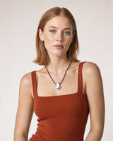 Model in a terracotta summer knit wearing the Naiya silver pebble cord necklace