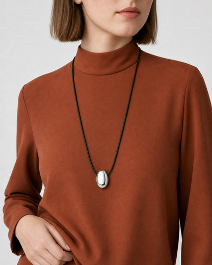 Eye-free upper-torso studio view wearing the Naiya silver pebble cord necklace