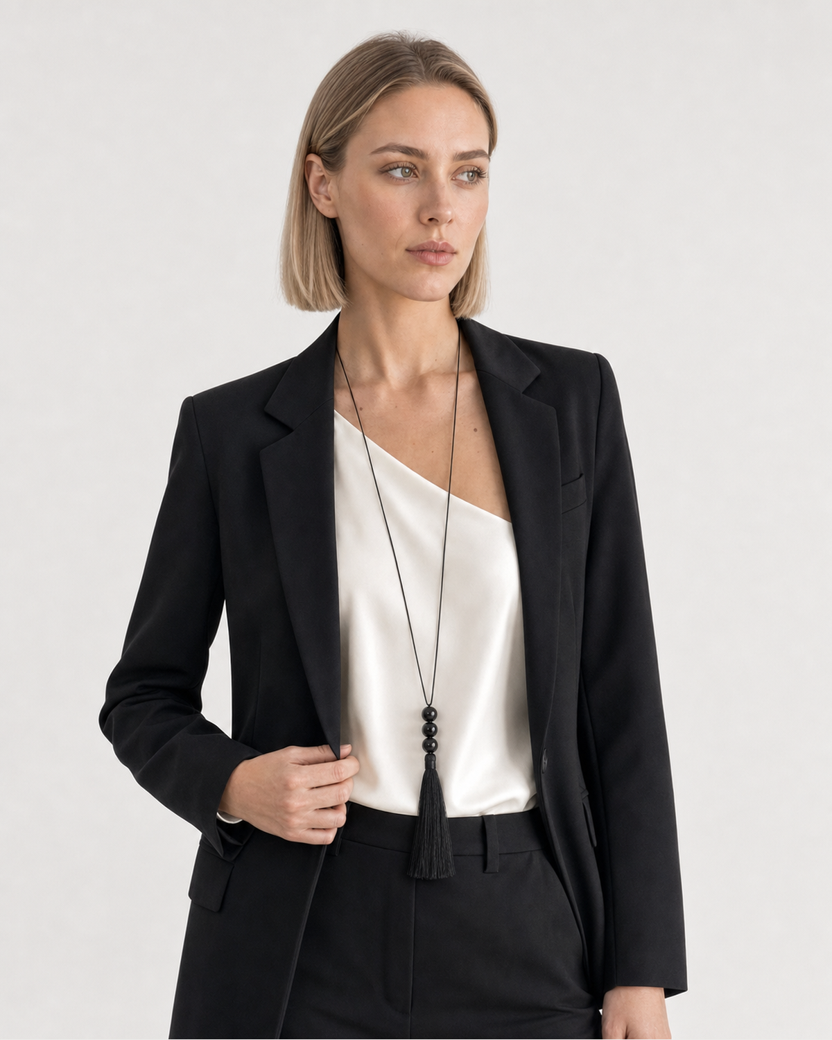 Alternate portrait of the same British model wearing the Nera black tassel necklace