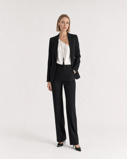 Wide studio portrait showing the Nera tassel necklace at natural scale with black tailoring