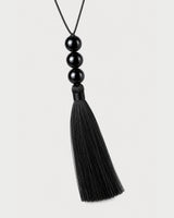 Straight macro of the Nera three glossy beads, wrapped neck and complete black tassel