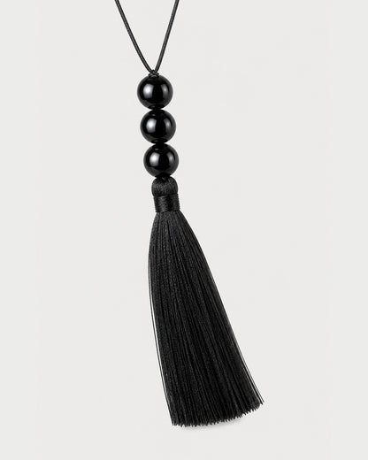 Straight macro of the Nera three glossy beads, wrapped neck and complete black tassel